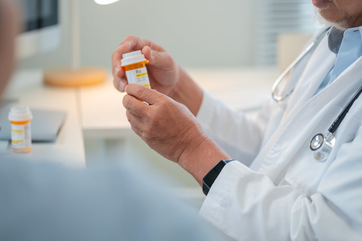 Male senior doctor discusses personalized medicine treatment with female patient hospital. Integrative healthcare approach